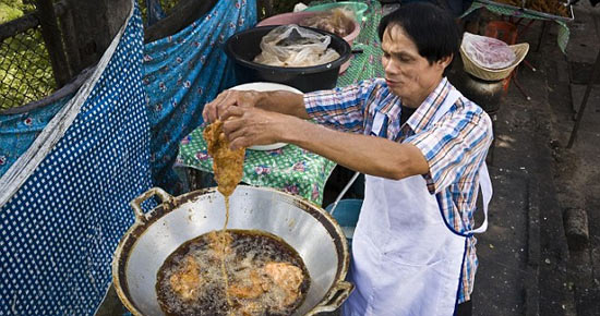 Повар из Таиланда способен жарить пищу голыми руками, так как у него не бывает ожогов