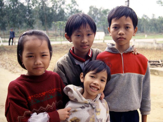Вьетнамские дети переправляются через реку в полиэтиленовых мешках
