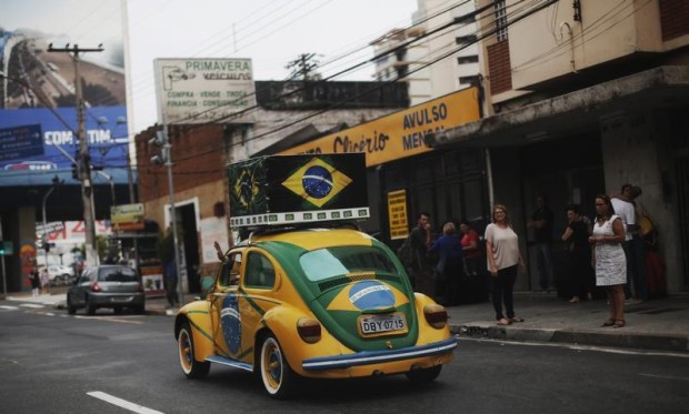 Brazilian attorney, Nelson Paviotti, drives one of his two Volkswagen Beetles painted with the colors of the national flag in Campinas
