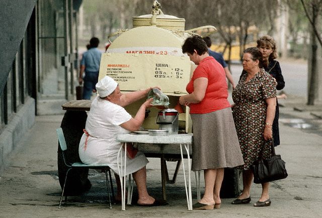 1987, Volgograd, USSR --- A woman on a street in Volgograd sells some sort of liquid for the invalids of the Great Patriotic War (the Soviet name for World War II). --- Image by © David Turnley/CORBIS