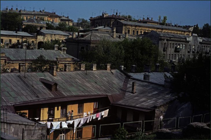 Ukraine. Odessa. Woman hanging out washing in a patch of sunshine in an overall view of the city. 1982