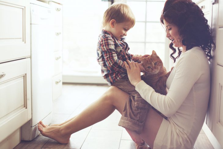 Mother and child playing with cat