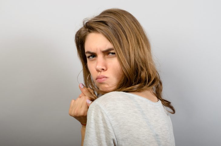 Closeup portrait greedy young woman holding dollar banknotes tightly isolated grey wall background