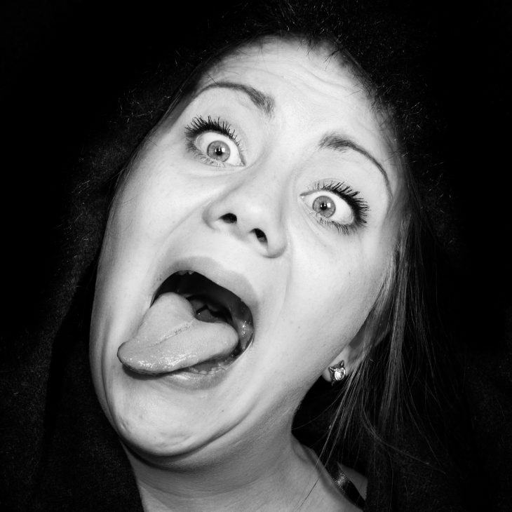 crazy woman with staring eyes and outstretched tongue