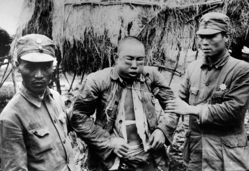 Пленный Китаец и японские солдаты на территории концлагеря в Южной Корее