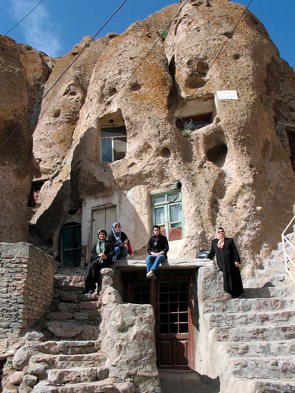 Жители Кандован на фоне фасада пещерного дома 